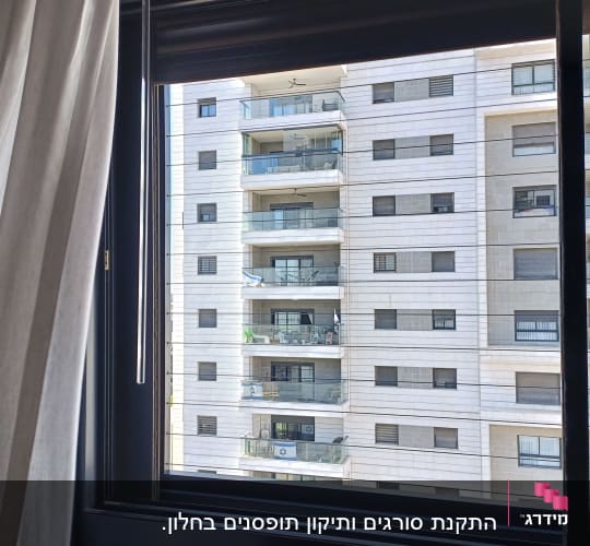 נוף של בניין מגורים מבעד לחלון פתוח